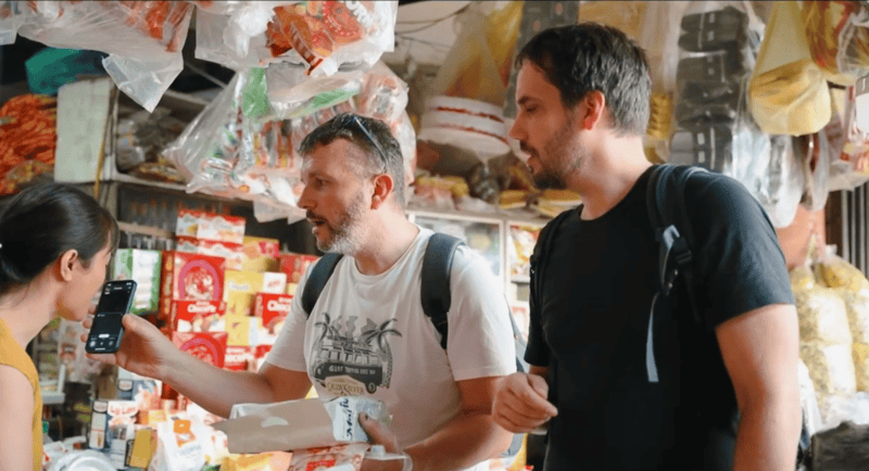 Teilnehmer von „Amazing Race Vietnam“ im Austausch mit Einheimischen während einer Geschäftsreise.